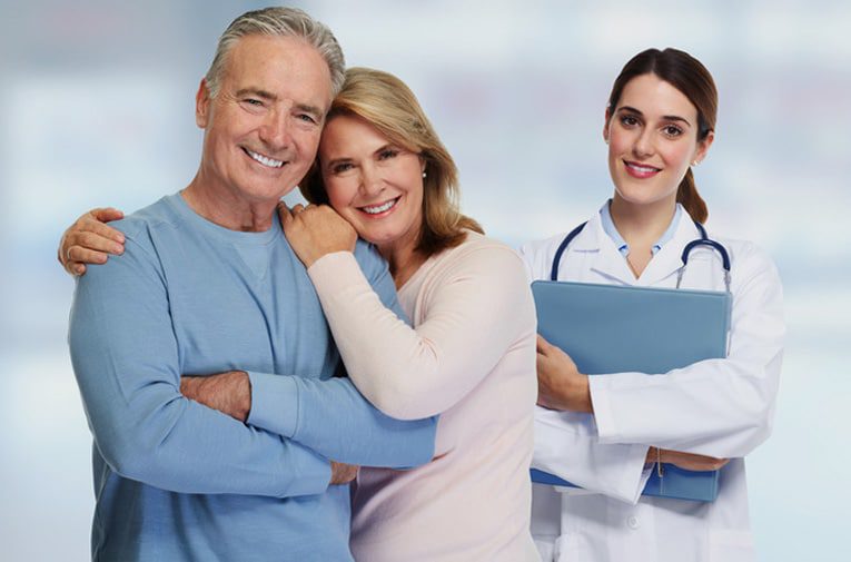 Happy middle-aged couple beside a woman healthcare professional